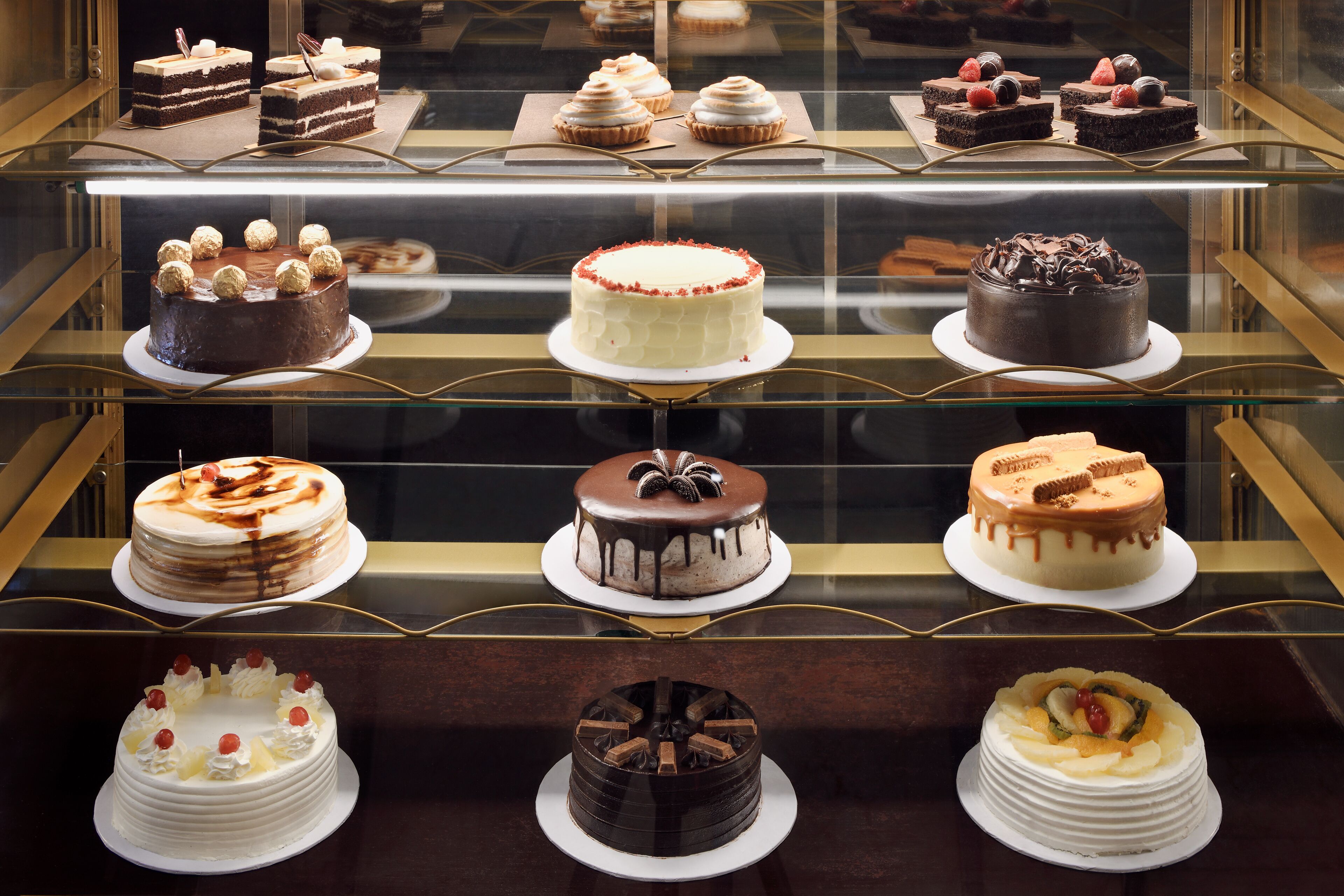 A display case with various cakes and pastries.