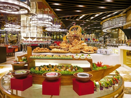 A buffet with various food items and a central decorative structure.. Mövenpick Hotel Karachi