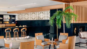 A modern lobby with a bar area, seating arrangements, and a decorative wall with geometric patterns.