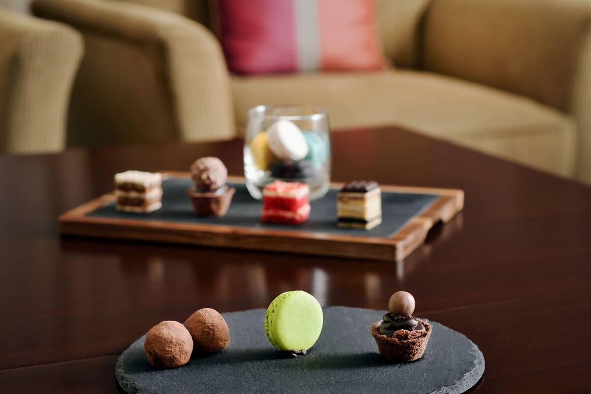 Eine Schale mit verschiedenen Desserts auf einem dunklen Tisch.
