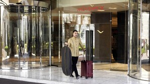 A hotel entrance with a revolving door and a sign reading "Mövenpick Hotel Karachi".