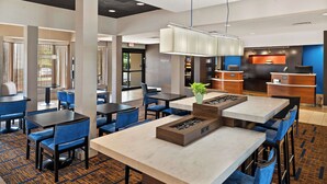 A hotel lobby with multiple seating areas, a reception desk, and a fireplace.