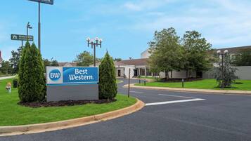 Señal de un hotel Best Western, con una carretera despejada y follaje circundante.