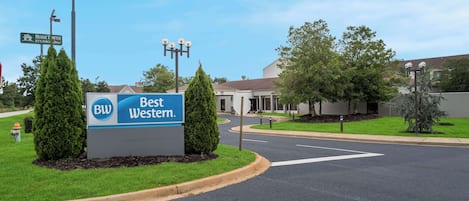 Señal de un hotel Best Western, con una carretera despejada y follaje circundante.