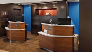 A reception area with two wooden reception desks, a blue accent wall, and a mounted television.