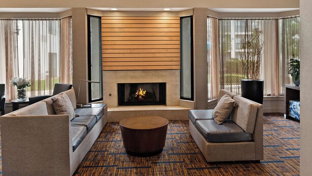 A modern living room with a fireplace, two sofas, and a coffee table.
