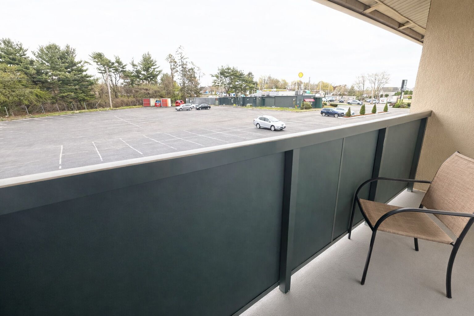 Un balcón con vista a un estacionamiento y edificios.