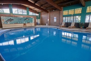 Una piscina techada, sillones reclinables de piscina