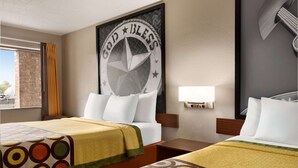 A hotel room with two beds, a large wall decoration, a window with curtains, and a wall-mounted light. - Super 8 by Wyndham Universal City (Universal City)