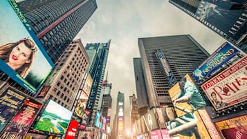 A cityscape with tall buildings and numerous billboards.