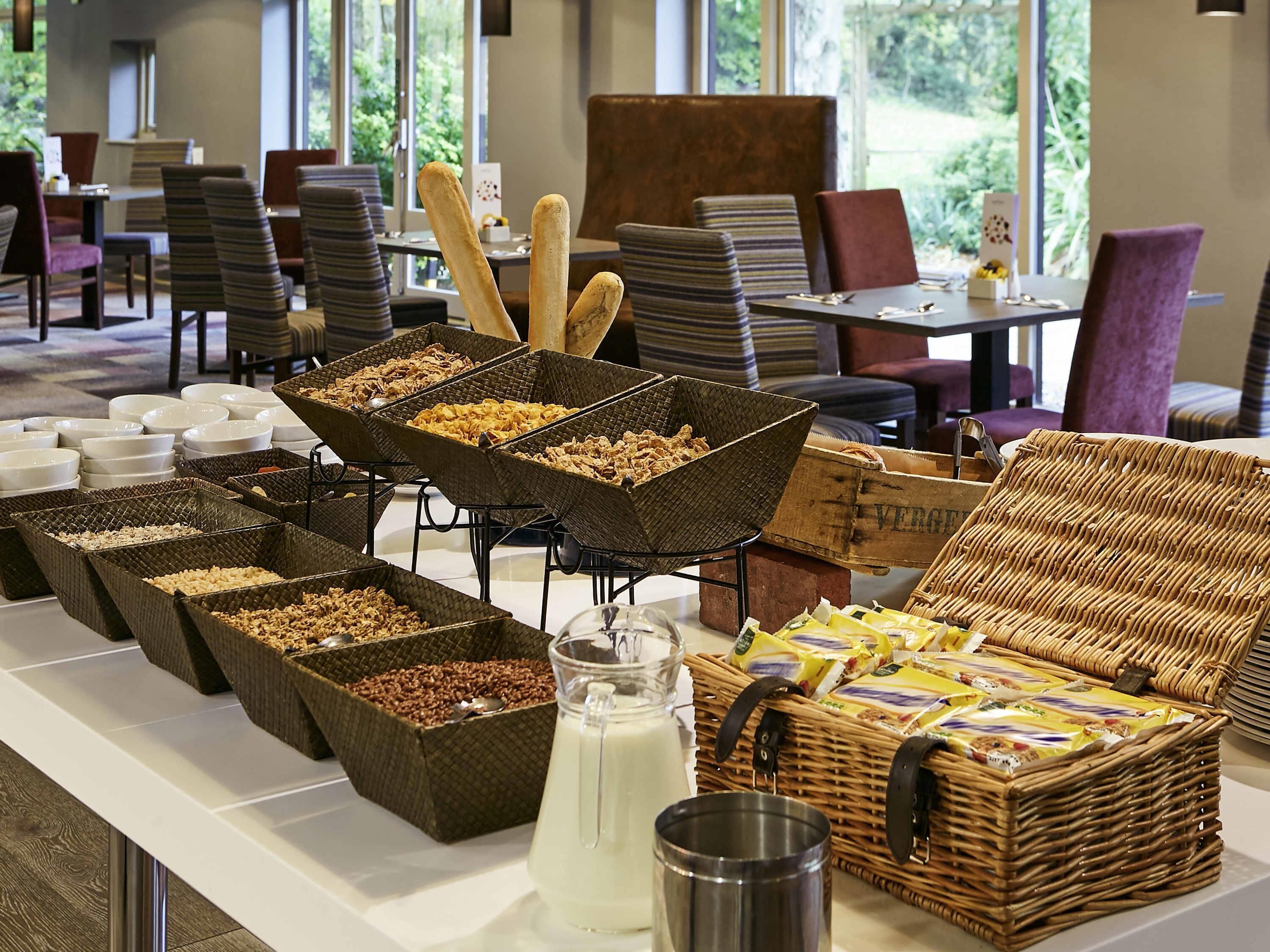 A buffet setup with various food items and a milk jug.