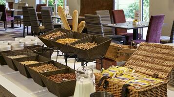 A buffet setup with various food items and a milk jug.