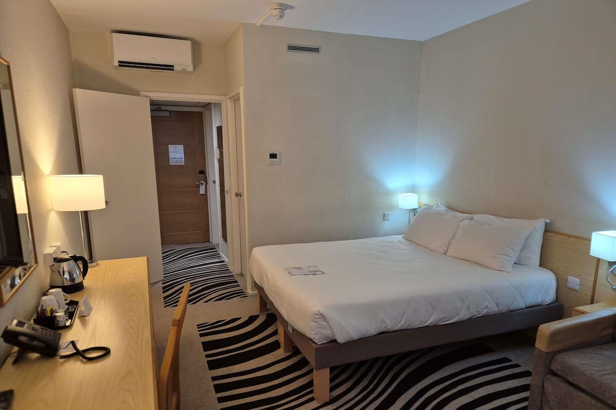 Hypo-allergenic bedding, desk, laptop workspace, blackout drapes