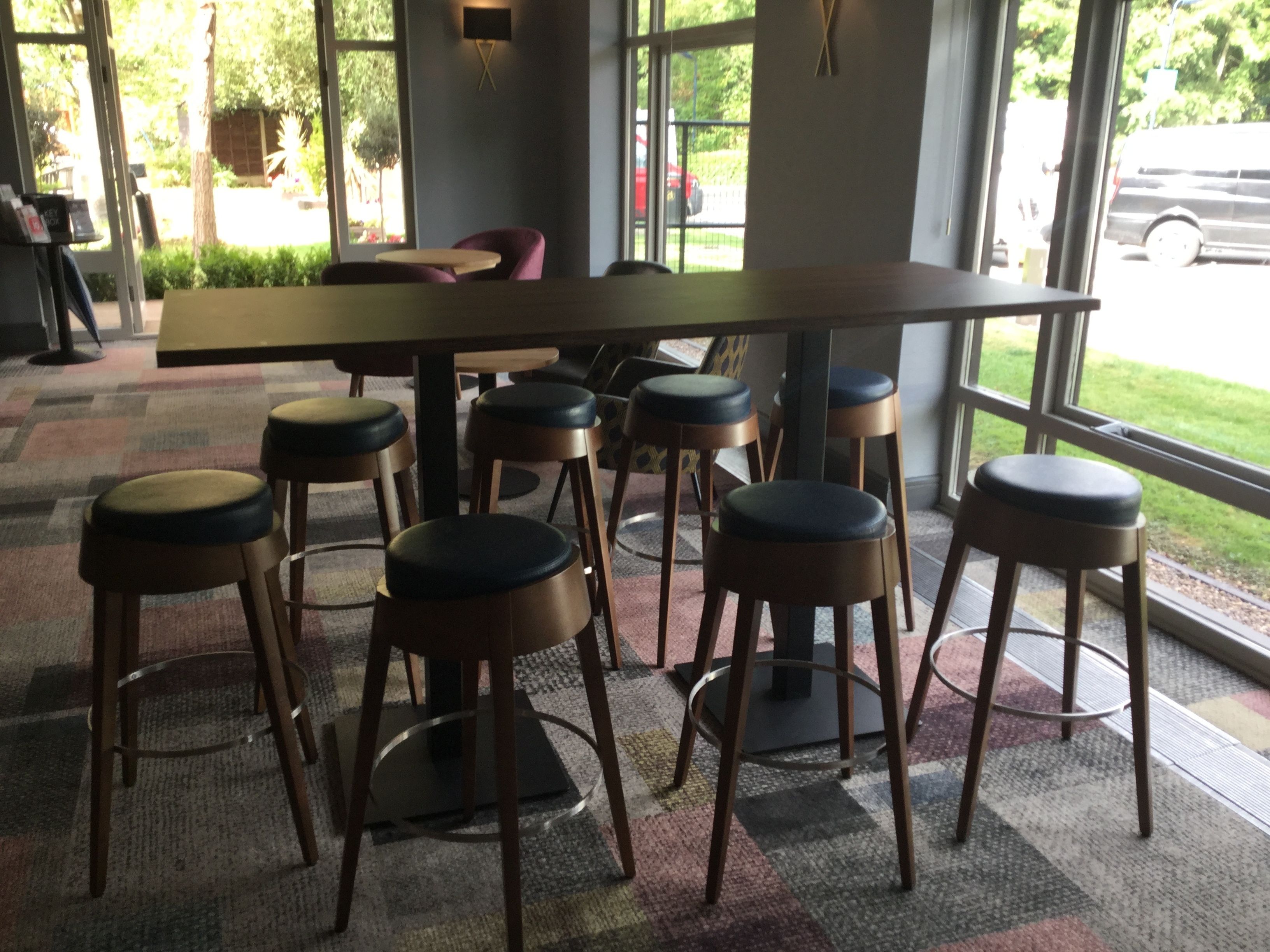 A modern interior with a long table and six stools.