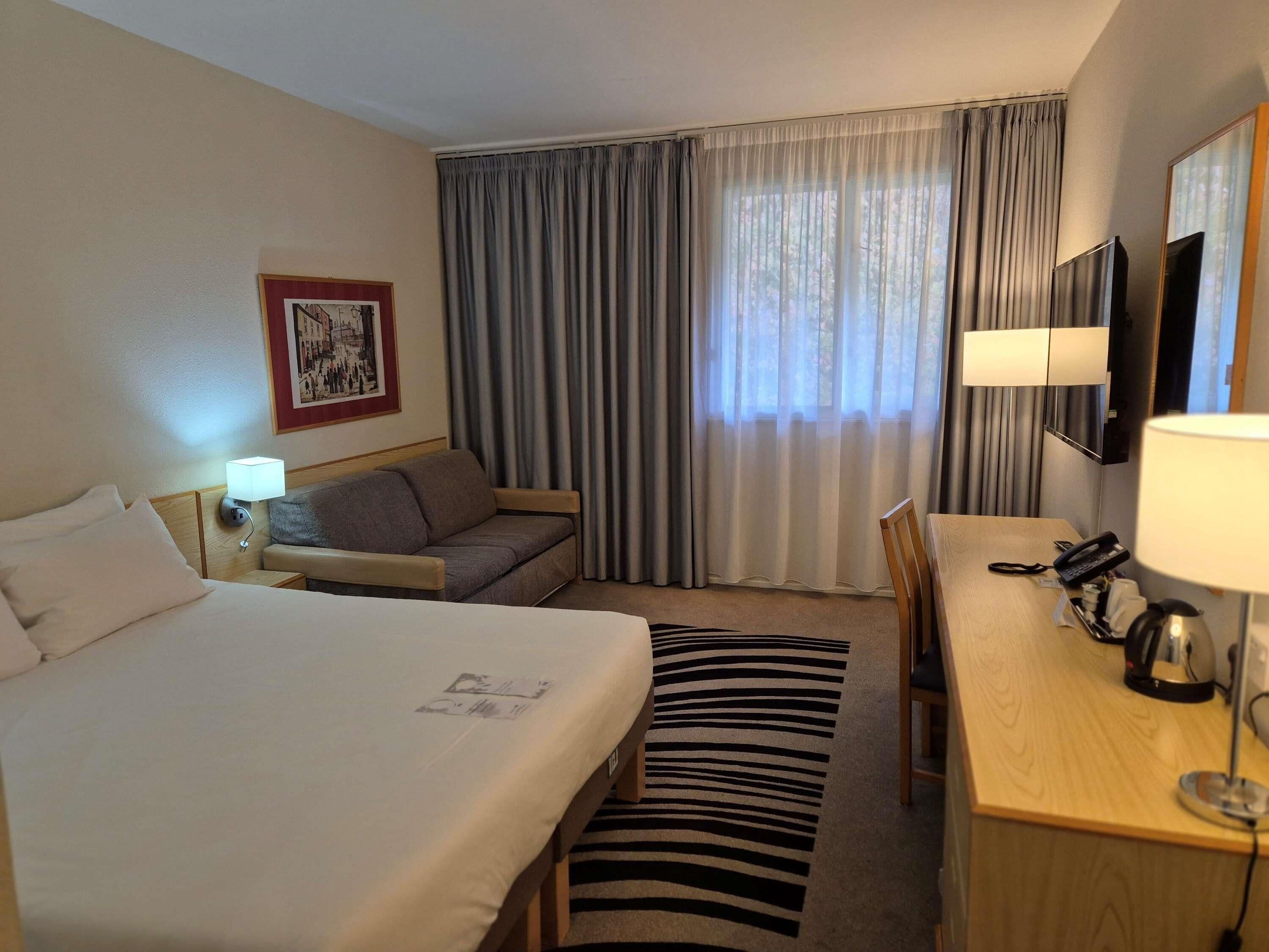 Hypo-allergenic bedding, desk, laptop workspace, blackout drapes