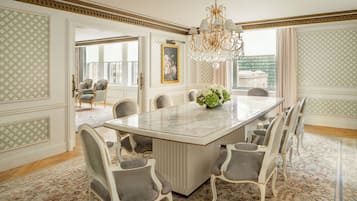 Un vaste espace dédié à la salle à manger, avec une table en marbre, des chaises élégantes et un lustre.