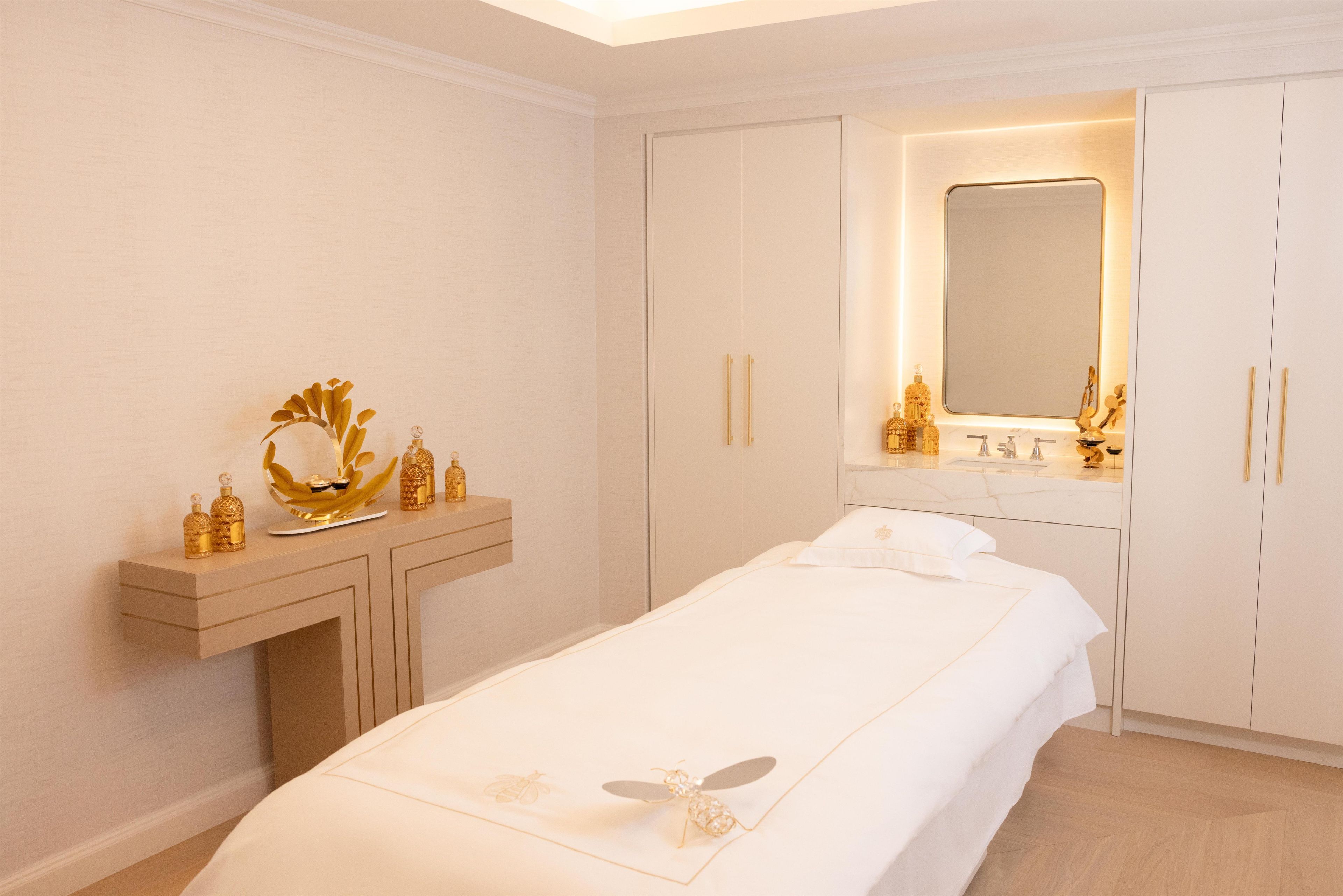 A bedroom with a bed, a vanity with a mirror, and a chest of drawers.