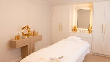 A bedroom with a bed, a vanity with a mirror, and a chest of drawers.