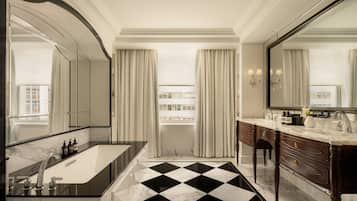 A luxurious bathroom with a black and white checkered floor, a large mirror, and a double vanity with a marble countertop.