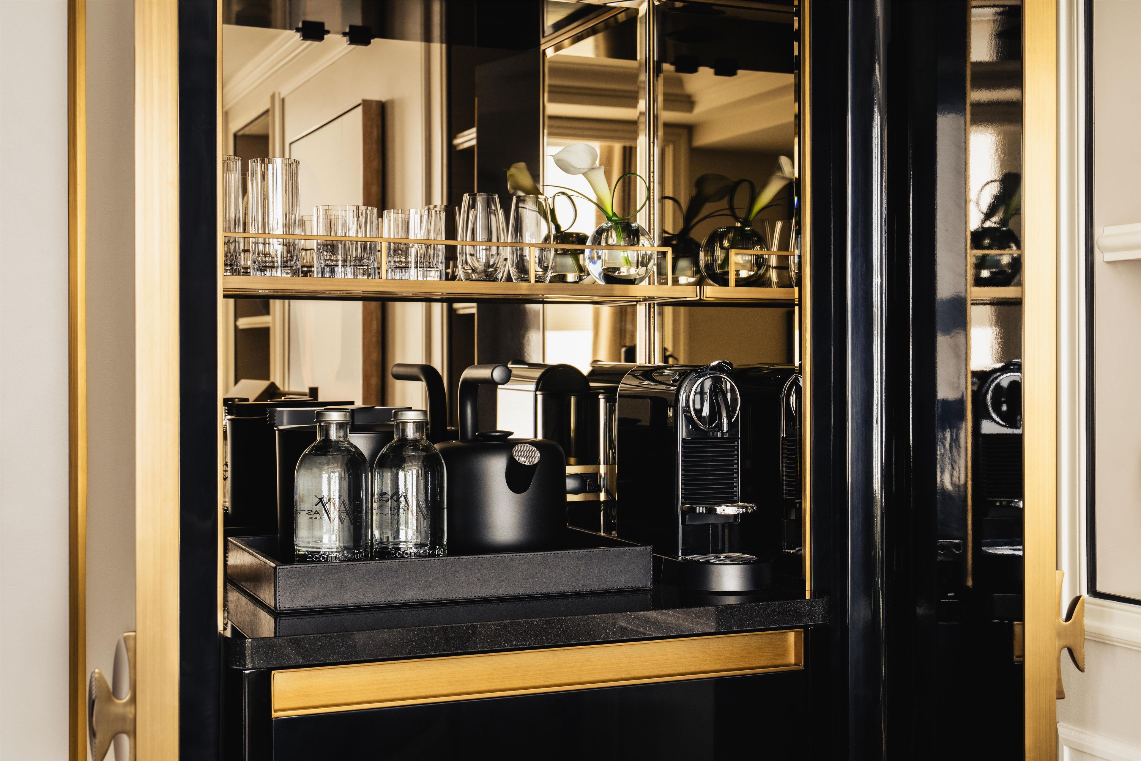A bar area with a mirrored wall, a coffee machine, and a glass display.
