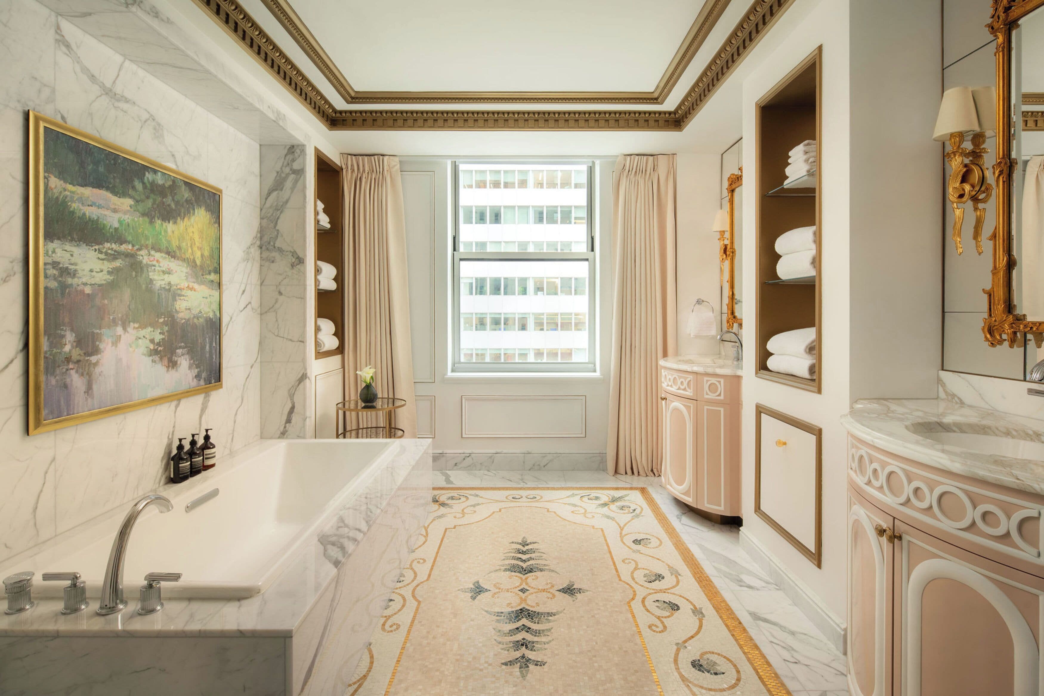 A luxurious bathroom with a marble sink, a large bathtub, and a decorative rug.