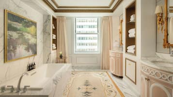 A luxurious bathroom with a marble sink, a large bathtub, and a decorative rug.