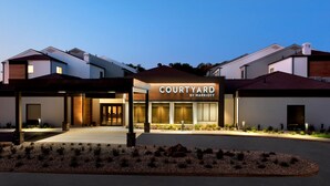 A modern hotel entrance with a sign reading "Courtyard by Marriott." - Courtyard New Haven Wallingford (Wallingford)