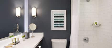 Un bagno moderno con un lavandino bianco, un water e una doccia.