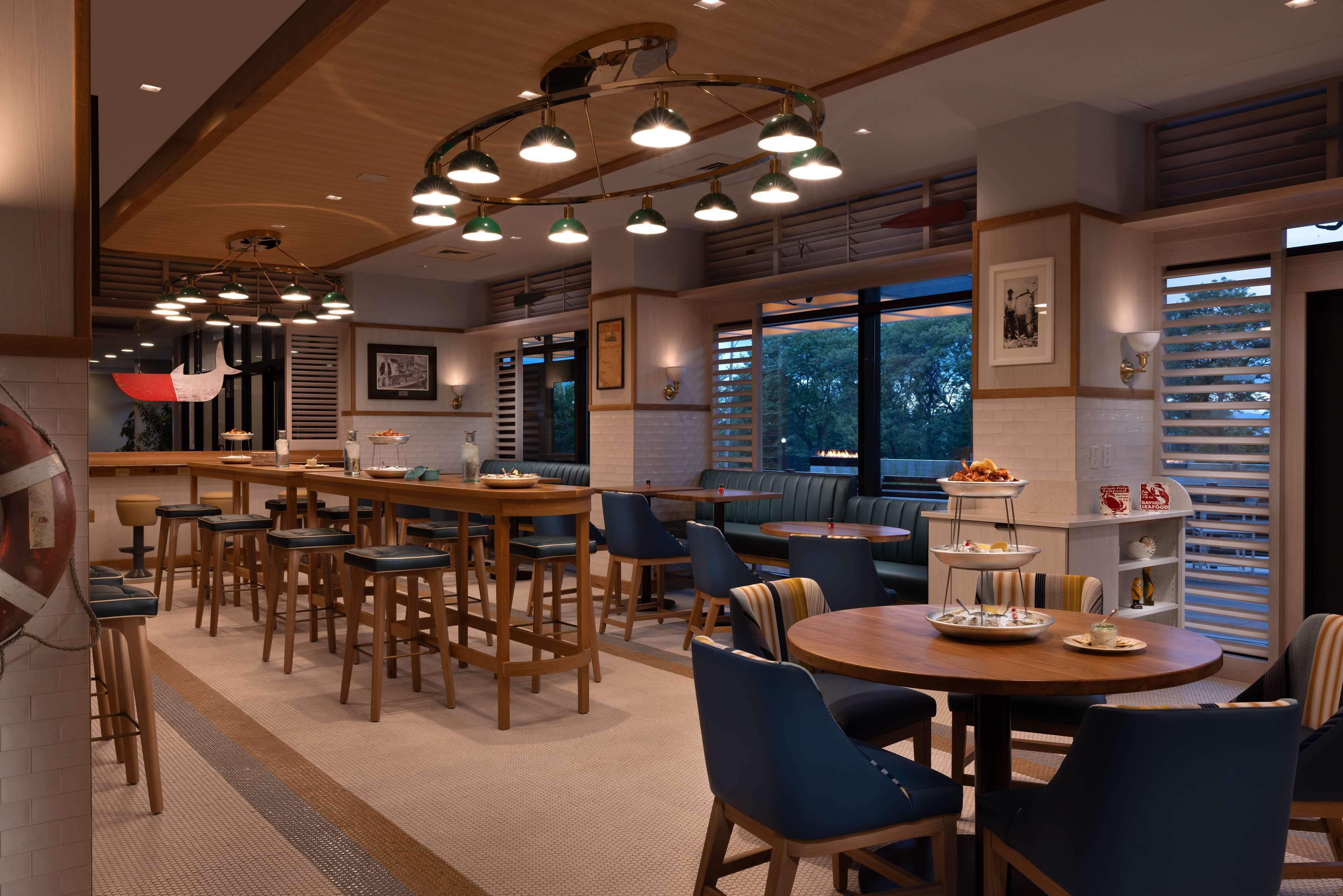 Un comedor espacioso con varias opciones de asientos, incluidas mesas altas y cabinas, además de una zona de bar con taburetes.