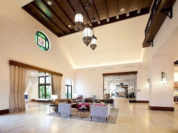 A restaurant interior with long tables, chairs, and a white wall with the restaurant