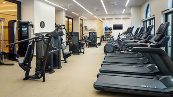 A gym with treadmills, weight machines, and exercise balls.