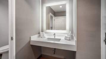 Une salle de bain avec un lavabo blanc, un miroir et un porte-serviettes.