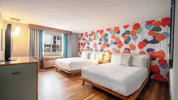 Une chambre d’hôtel avec deux lits, un bureau, une télévision et une fenêtre avec des rideaux.