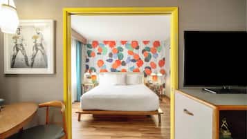 A hotel room with a bed, a TV, a desk, and a chair.
