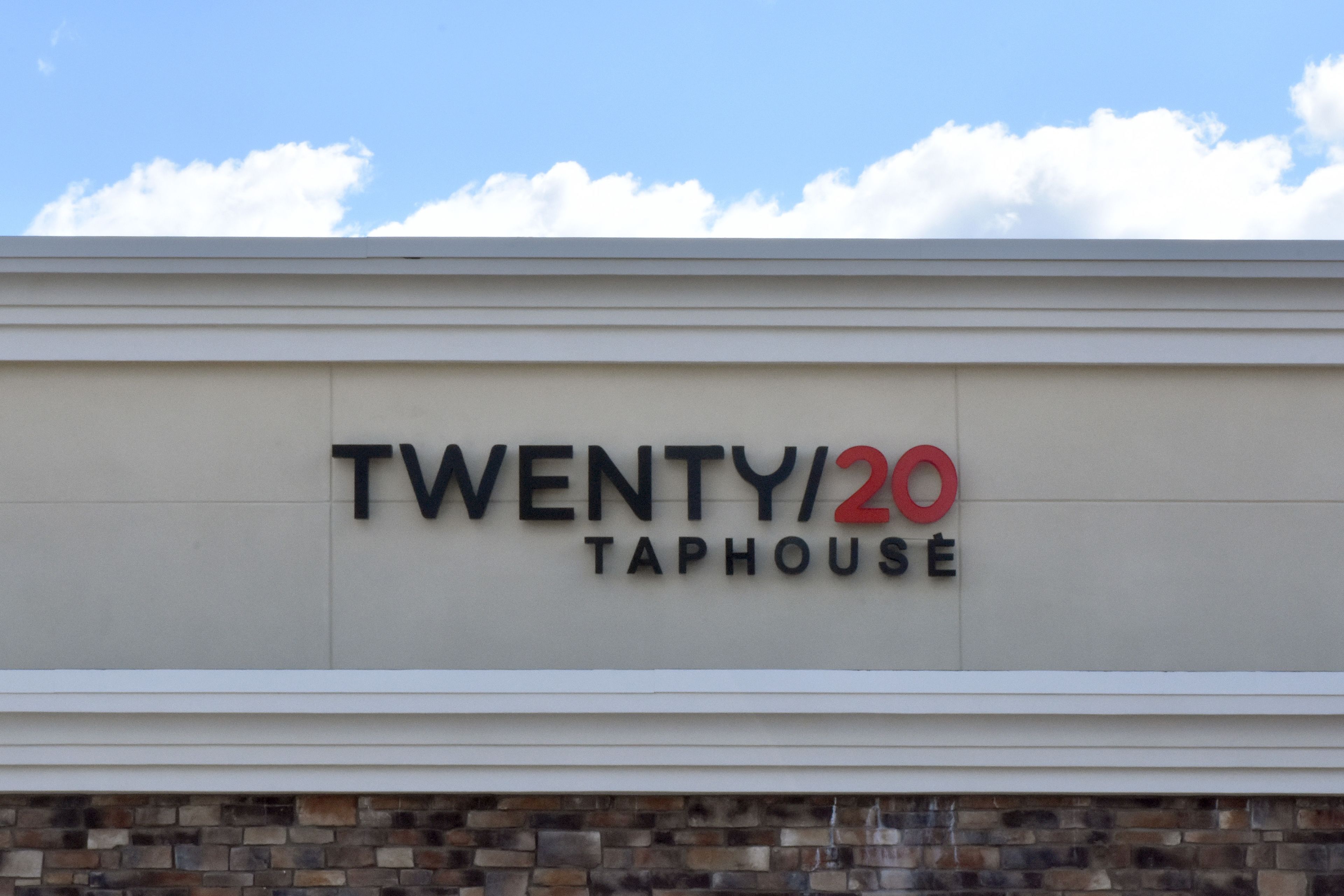 A sign for "TWENTY/20 TAPHOUSE" on a building facade.
