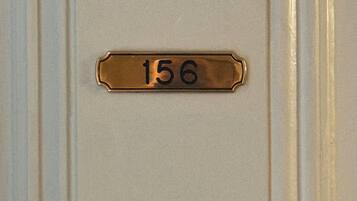 A brass doorplate with the number 156.