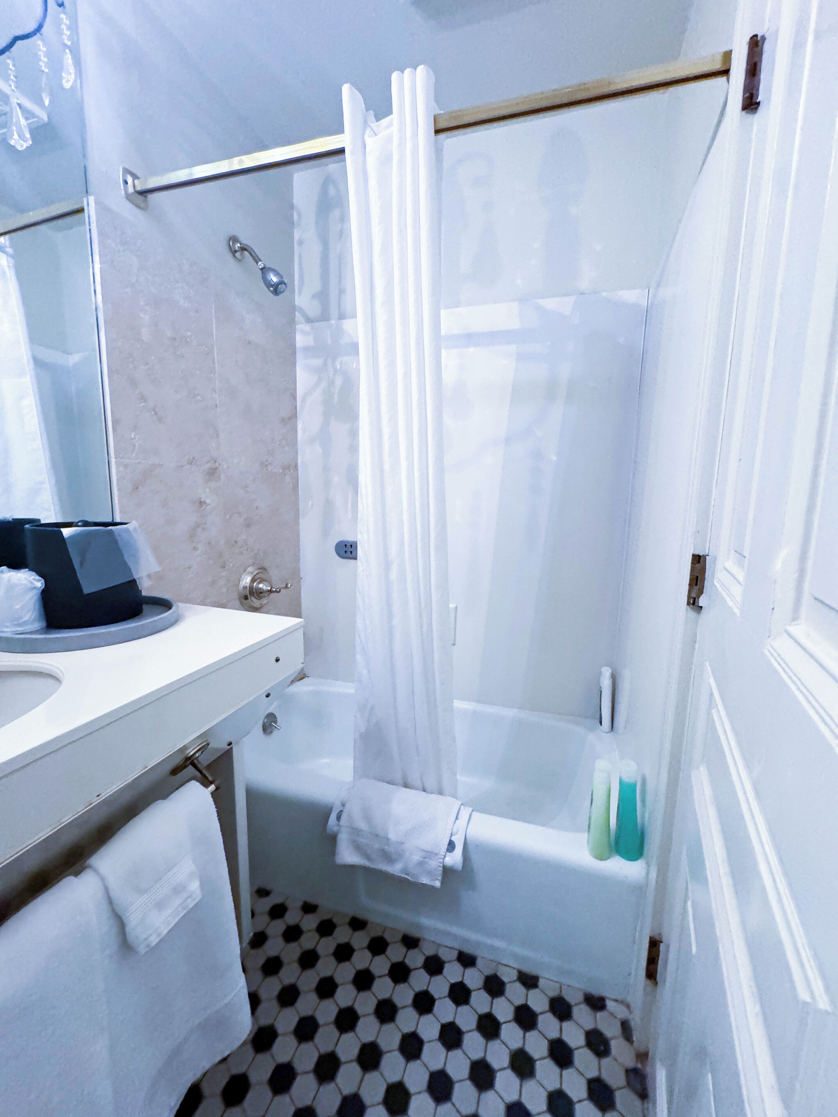 A bathroom with a white bathtub, a glass shower enclosure, a white sink, and a mirror.