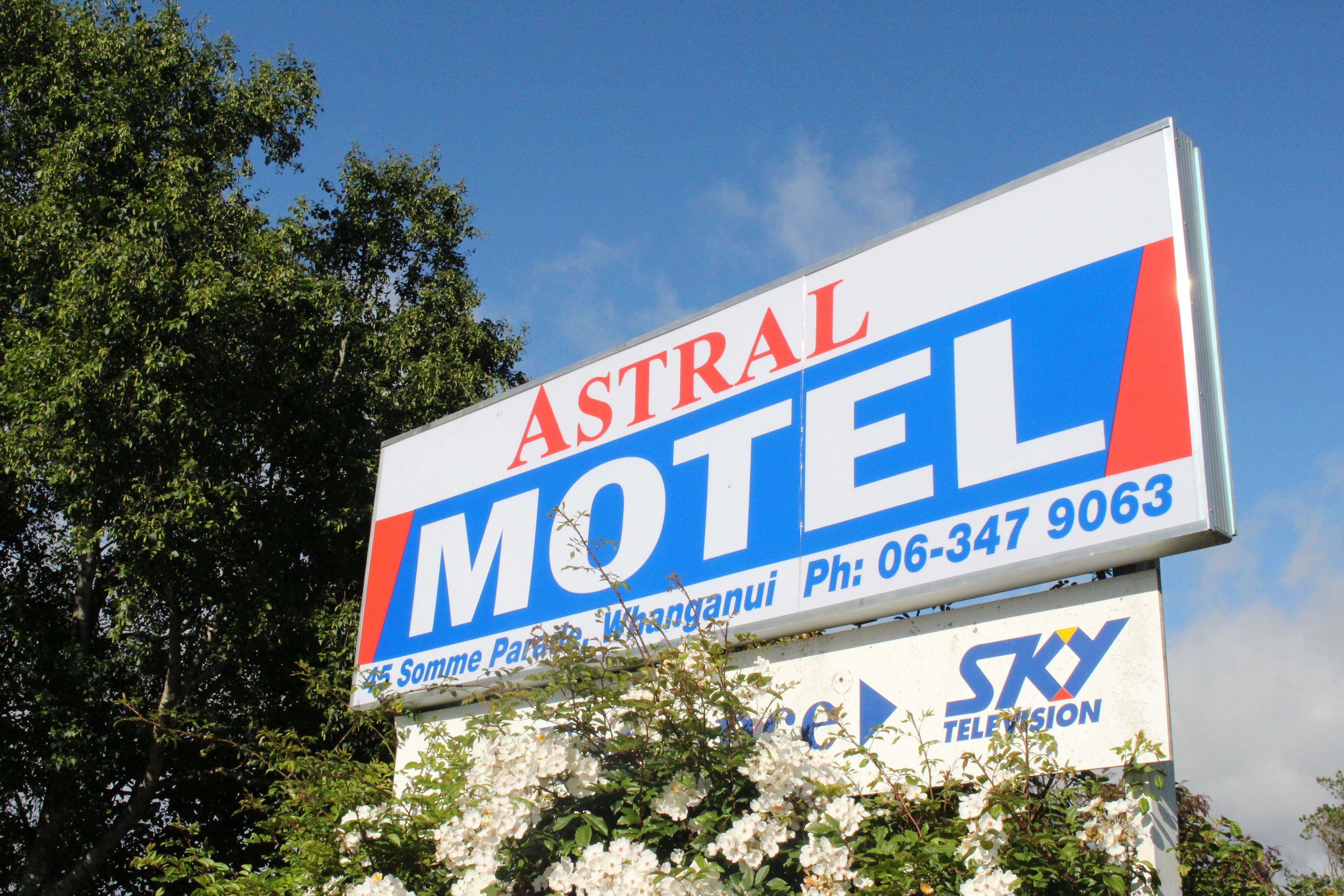 Un panneau indiquant un motel, avec l’inscription « Astral Motel » et un numéro de téléphone.