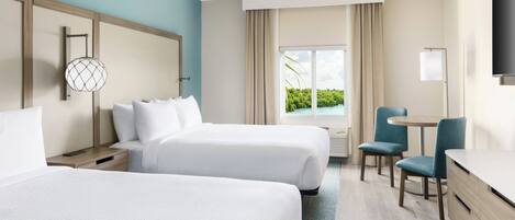 A hotel room with two beds, a desk, a chair, and a TV.