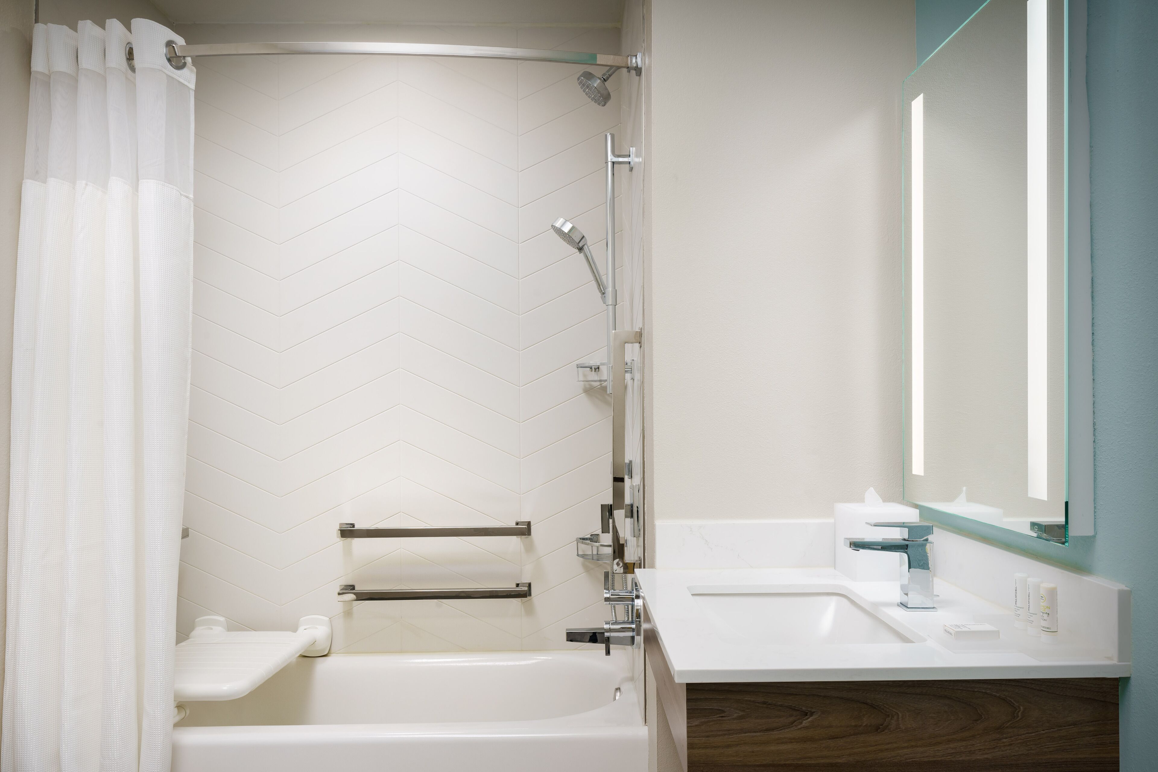 A modern bathroom with a bathtub, shower, and sink.