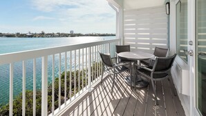 A balcony with a view of the ocean, a round table, and two chairs. - Fairfield Inn & Suites by Marriott Marathon Florida Keys (Marathon)