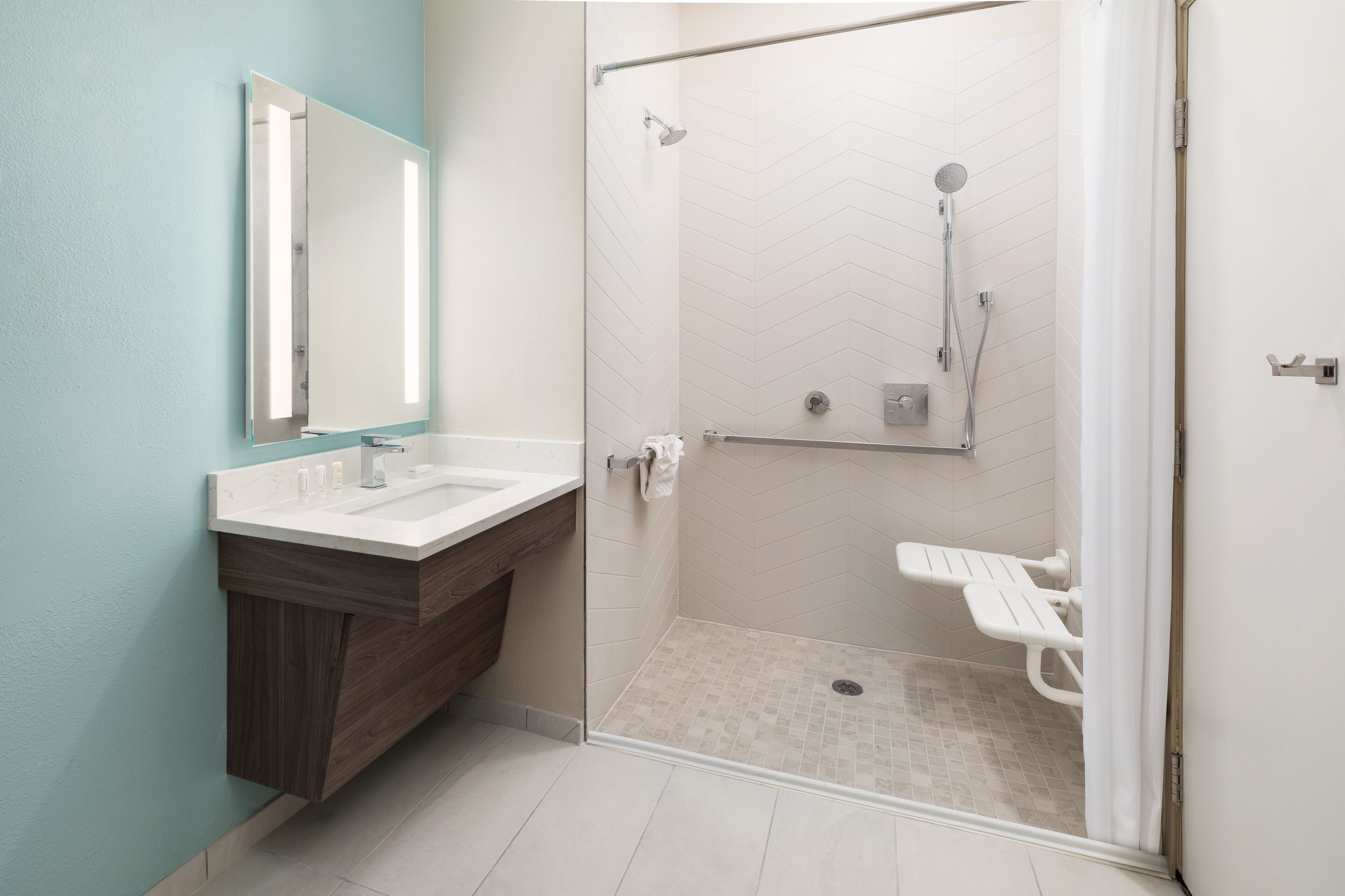 Un baño con ducha envuelta en cristal, tocador con espejo e inodoro con función bidé.