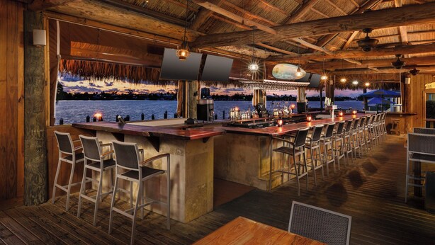 A bar area with a long counter, bar stools, and a view of the water. - Fairfield Inn & Suites by Marriott Marathon Florida Keys (Marathon)