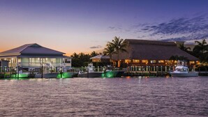 A waterfront property with a large building, a smaller structure with a thatched roof, and several boats docked. - Fairfield Inn & Suites by Marriott Marathon Florida Keys (Marathon)
