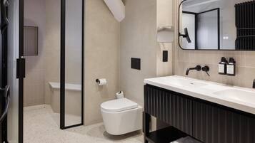 A modern bathroom with a shower, toilet, and sink.