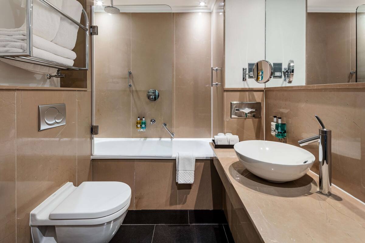 Une salle de bain moderne avec une baignoire, des toilettes et un grand lavabo.