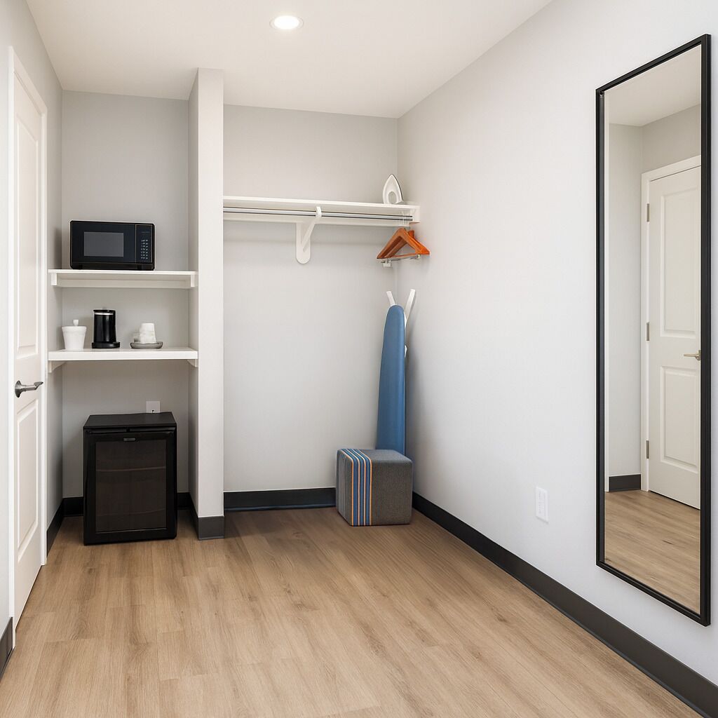 Habitación compacta con microondas, cafetera y un mueble pequeño.