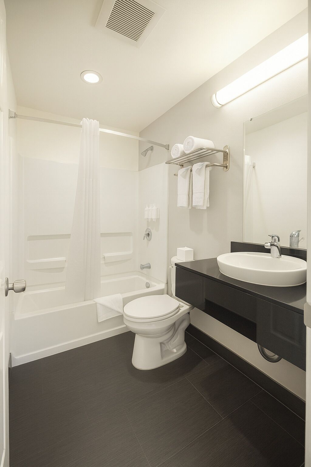 A modern bathroom with a bathtub, toilet, and sink.