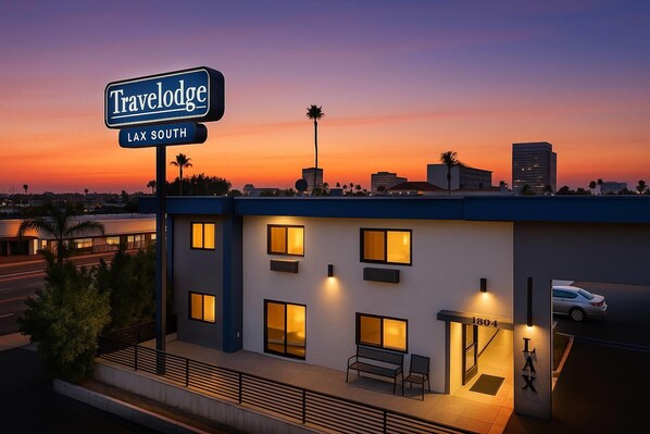 A Travelodge hotel with a sign indicating it's in Lax South. It features a modern design with large windows and a flat roof. - Travelodge by Wyndham LAX (El Segundo)