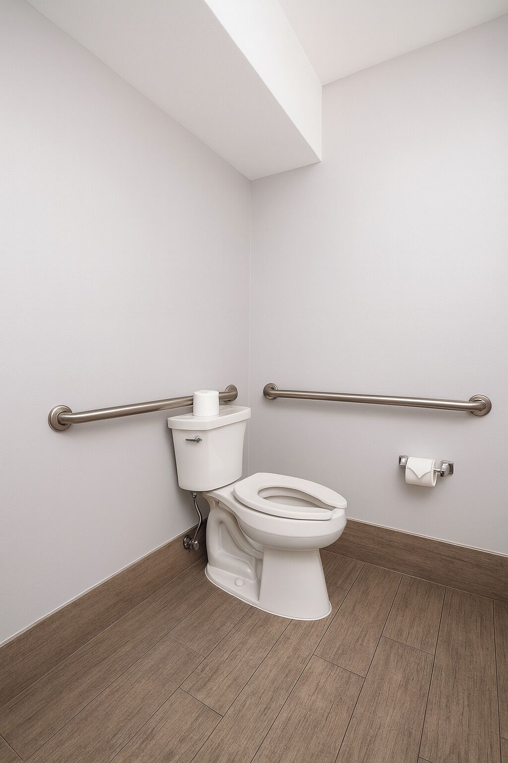 A modern bathroom with a toilet, grab bars, and a wooden floor.